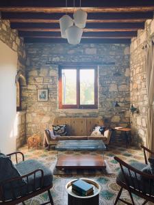 salon z kanapą i kamienną ścianą w obiekcie The Goathouse w Larnace