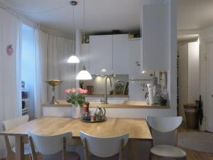 コペンハーゲンにあるApartmentInCopenhagen Apartment 655のキッチン(木製テーブル、白いキャビネット付)