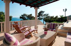 une terrasse couverte avec des chaises et une table. dans l'établissement Villa Luciana, à Mimice