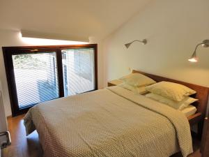 a bedroom with a bed and a large window at Apartamentos La Collada in San Pelayo de Tehona
