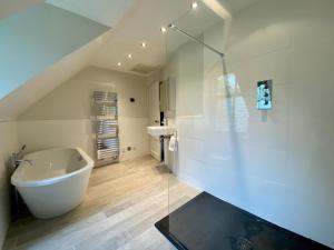 ein weißes Badezimmer mit Badewanne und Waschbecken in der Unterkunft Dunvegan Castle Gardens Cottage in Dunvegan + 9 Fotos