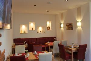 a restaurant with two tables and chairs and a couch at Pension Alscher Garni in Goslar