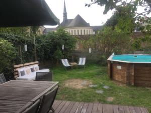 a backyard with a pool and a table and chairs at Abbey Road Le Thoureil in Le Thoureil