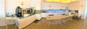 a room with a kitchen with a counter and a table at Hotel Mediterrani in Calella de Palafrugell