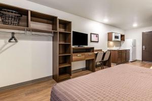a hotel room with a bed and a desk with a computer at WoodSpring Suites Indianapolis Airport South in Indianapolis