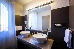 La salle de bains est pourvue de 2 lavabos et d'un grand miroir. dans l'établissement Hôtel Radio - Teritoria, à Chamalières