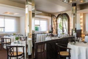 une salle à manger avec des tables et des nappes blanches dans l'établissement Hôtel Radio - Teritoria, à Chamalières