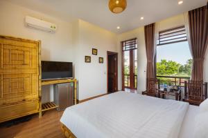 een slaapkamer met een bed en een flatscreen-tv bij MH Cherish Homestay in Ninh Binh