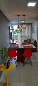 una sala de estar con 2 sillas rojas y una mesa. en No coração de Tambaú. Eco Summer, en João Pessoa