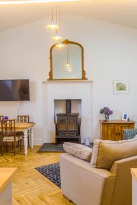 a living room with a couch and a fireplace at The Old Sunday School in Helston