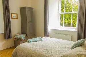 a bedroom with a large bed and a window at The Old Sunday School in Helston