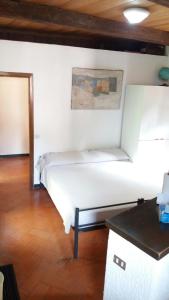 a bedroom with a white bed and a wooden floor at Fontantica di Vernazza cod citra 011030-lt-0043 in Vernazza