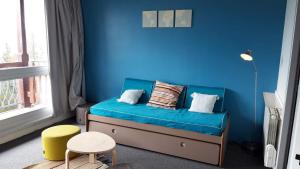 a blue room with a bed with a blue wall at travelski home select - Résidence Thuria in Arc 1800