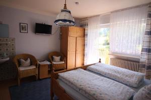 1 dormitorio con 2 camas, TV y ventana en Gästehaus Schreiner, en Sankt Oswald