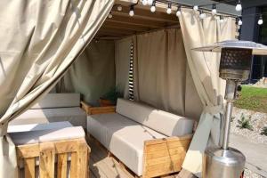 a tent with a couch and a table and a lamp at Apartamentai su terasa in Palanga