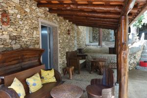 Habitación con cama y pared de piedra. en Quinta Dos Carvalhos en Vilarinho de Agrochão