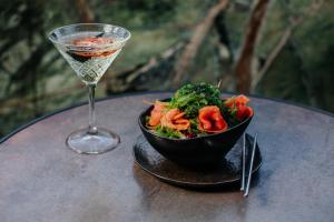 a bowl of salad and a glass of wine on a table at Napa Plaza Hotel (Adults Only) in Ayia Napa