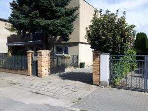 a fence in front of a house with a tree at Villa Belveder in Poznań