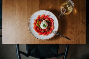 a plate of vegetables on a table with a glass of wine at Napa Plaza Hotel (Adults Only) in Ayia Napa