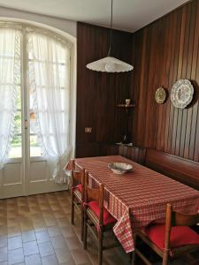 d'une salle à manger avec une table, des chaises et une fenêtre. dans l'établissement Casa Vacanze - Residenza Elvezia, à Tirano