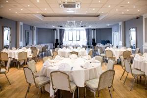 a banquet hall with white tables and chairs at The Sea Hotel in South Shields
