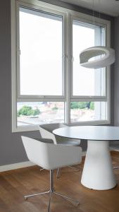a white table and chairs in a room with windows at Thon Hotel Panorama in Oslo