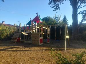 un parque infantil con tobogán y estructura de juegos en Chez Celine et Philippe Chambre atelier dans propriété de charme avec piscine, en Le Fossat