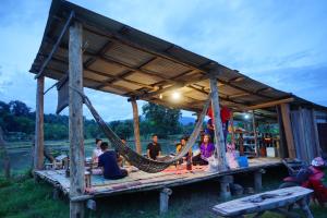 a group of people sitting in a hammock at Wanmai Farm Stay Muangkong วันใหม่ฟาร์มสเตย์ เมืองคอง เชียงดาว in Ban Yang Nong Bua