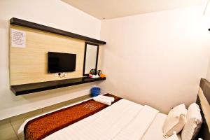 a hotel room with a bed and a flat screen tv at Hotel Rasah Seremban in Seremban