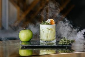a drink and an apple on a table with smoke at Napa Plaza Hotel (Adults Only) in Ayia Napa