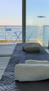 łóżko z dwoma poduszkami na górze przed oceanem w obiekcie Ostria Studios w Retimnie