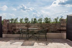 a table and chairs on a patio with a brick wall at Waldhotel zum Bergsee Damme in Damme