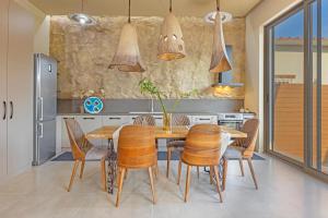 een keuken met een houten tafel en stoelen bij Gaia Blue Villa in Kolimbia