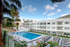 een uitzicht op het zwembad van een resort bij Hotel El Pinar in Cala Llonga