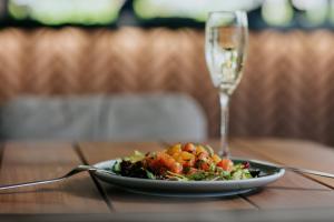 un plato de ensalada y una copa de vino en una mesa en Napa Plaza Hotel (Adults Only) en Ayia Napa