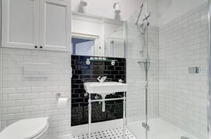 Dom & House Apartments Old Town Dluga في غدانسك: حمام أبيض مع حوض ودش