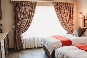 um quarto com 2 camas e uma grande janela em Iso'Bella Vita Guesthouse em Phalaborwa
