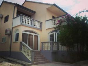 a house with stairs and balconies on top of it at Apartman Vukoja Pakostane in Pakoštane
