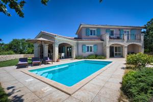 a villa with a swimming pool in front of a house at Villa Krmed by Istra Vacation in Krmed