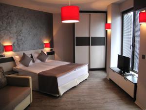 a bedroom with a bed and a couch and a television at Gran Via in Burgas City