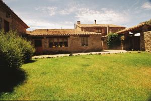 una casa con un patio de hierba delante de ella en La Trocha De Hoyorredondo, en Hoyorredondo