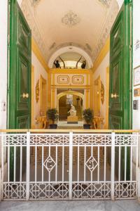 una habitación con puertas verdes y una escalera con una estatua en Casa Rocca Piccola B&B, en La Valeta