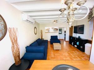 ein Wohnzimmer mit einem blauen Sofa und einem Kronleuchter in der Unterkunft Condo de Cortez in Puerto Peñasco