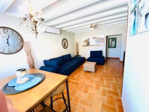 a living room with a blue couch and a clock at Condo de Cortez in Puerto Peñasco