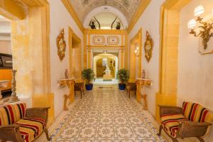 um corredor com cadeiras e uma escada num edifício em Casa Rocca Piccola B&B em Valletta