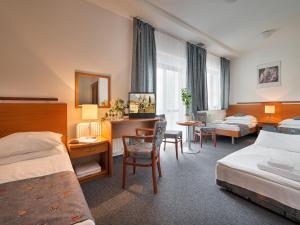 プラハにあるEA ホテル ポプラスのベッド2台とデスクが備わるホテルルームです。