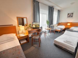 una camera d'albergo con 2 letti e una scrivania di EA Hotel Populus a Praga
