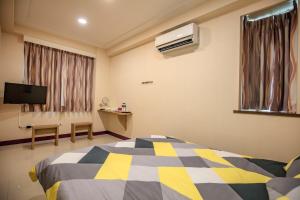 a bedroom with a bed and a tv and a window at 106 Homestay in Ruifang