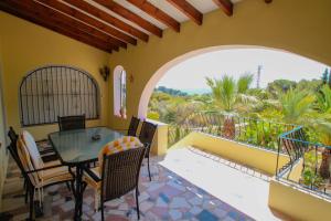 een patio met een tafel en stoelen op een balkon bij Diana - pretty holiday property with garden and private pool in Benissa in Benissa