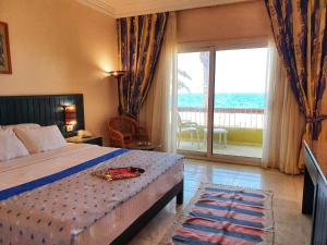 1 dormitorio con 1 cama y una gran puerta corredera de cristal en Palm Beach Resort Families and Couples only en Hurghada